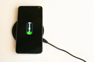 Carregador por indução: smartphone carregando sem fio. Bateria cheia.