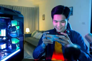 Gamer jogando no celular. Luvas de dedo gamer para precisão.